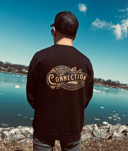 Man wearing black nickel city connection sweatshirt by water