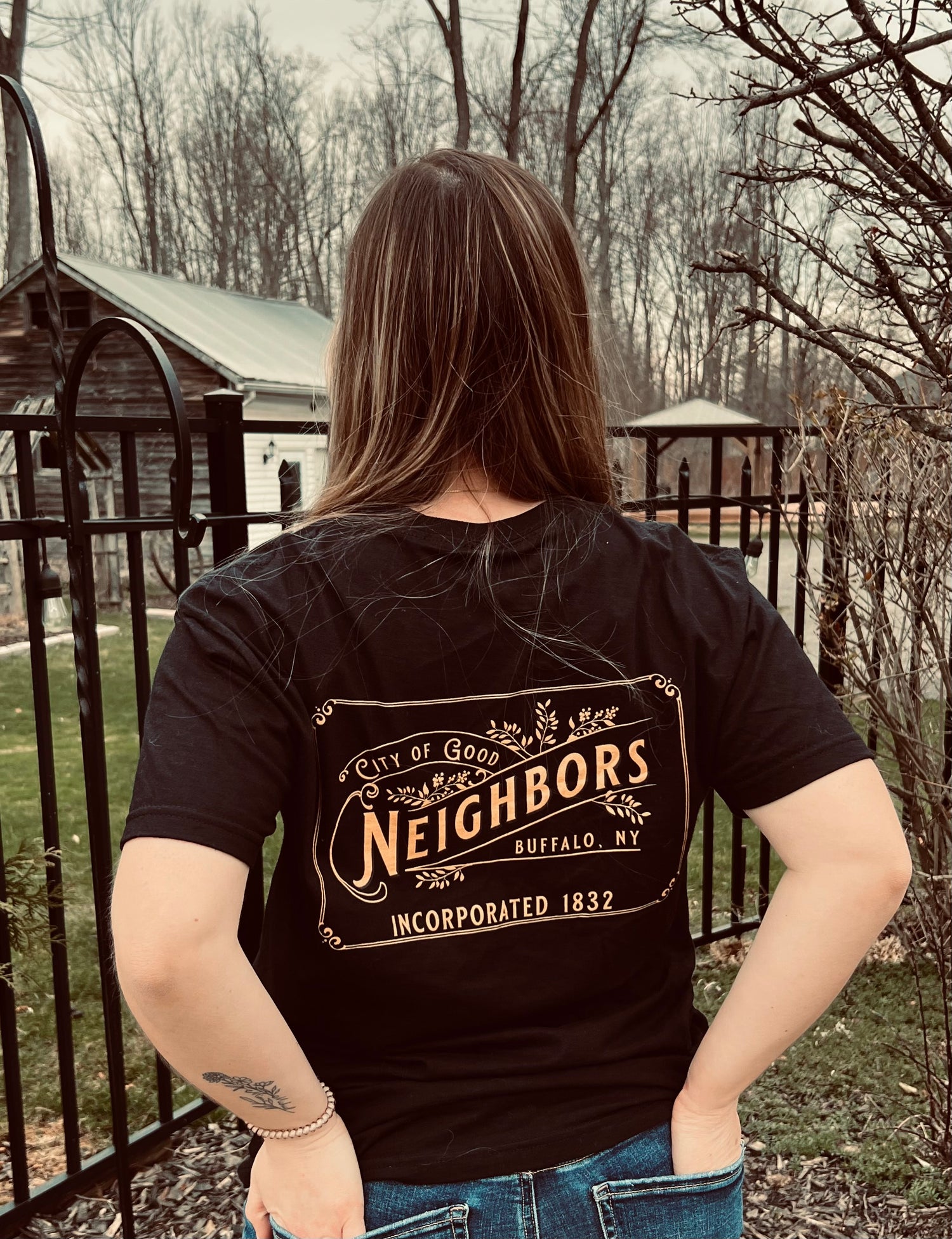Woman wearing black tshirt outside that reads city of good neighbors
