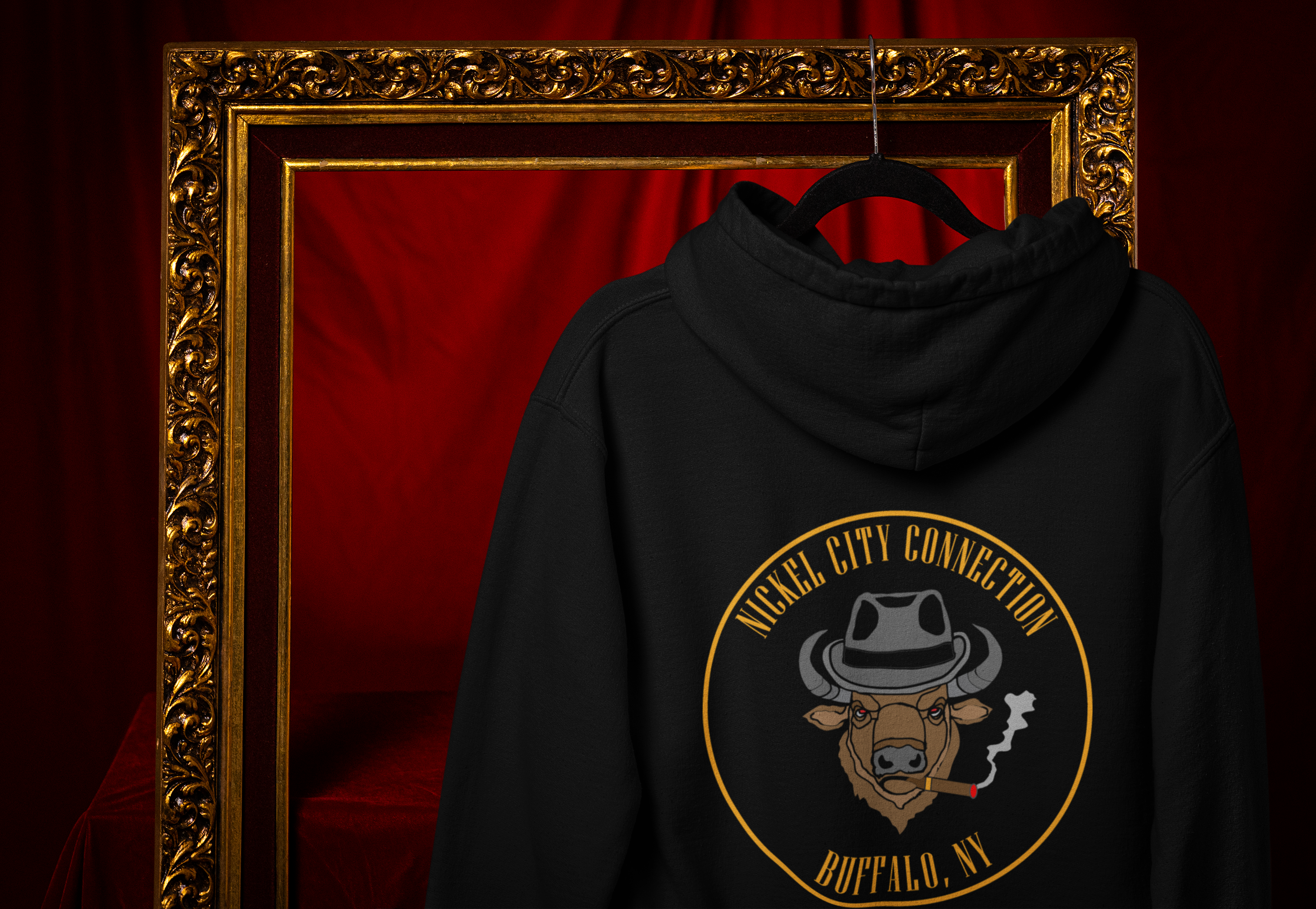 Nickel City Connection hoodie hanging on a gold frame and a red background