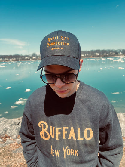 Man wearing black Buffalo sweatshirt by water