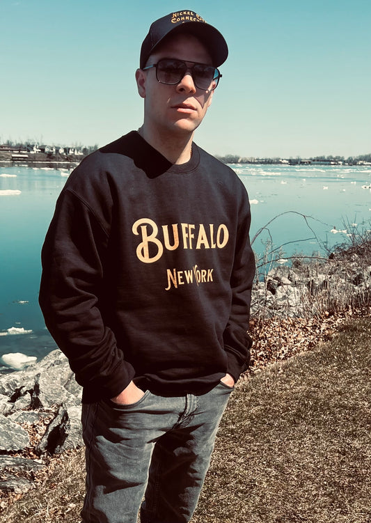 Man wearing black Buffalo sweatshirt by water