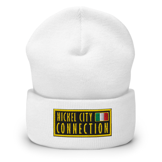 White beanie featuring An embroidered patch design featuring the text "NICKEL CITY CONNECTION" in bold, yellow capital letters on a black background. The text is enclosed in a yellow rectangular border. To the right of the text, there is a small embroidered Italian flag with green, white, and red vertical stripes, also bordered in yellow. 