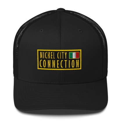 Black trucker hat featuring an embroidered patch design featuring the text "NICKEL CITY CONNECTION" in bold, yellow capital letters on a black background. The text is enclosed in a yellow rectangular border. To the right of the text, there is a small embroidered Italian flag with green, white, and red vertical stripes, also bordered in yellow.