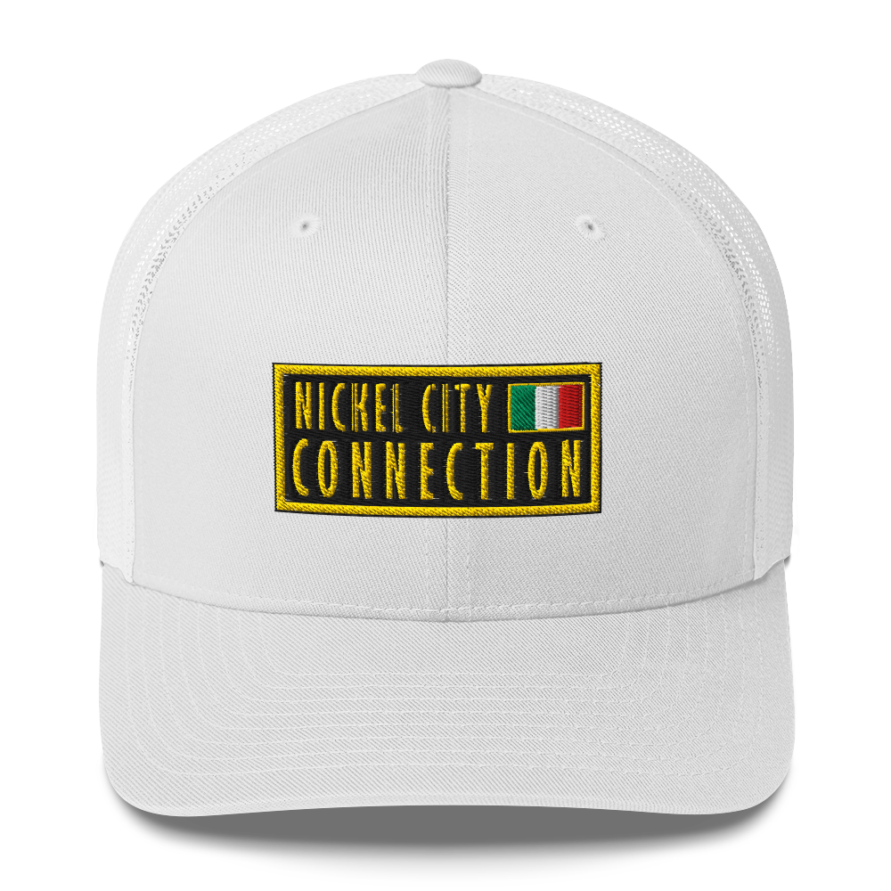 White trucker hat featuring an embroidered patch design featuring the text "NICKEL CITY CONNECTION" in bold, yellow capital letters on a black background. The text is enclosed in a yellow rectangular border. To the right of the text, there is a small embroidered Italian flag with green, white, and red vertical stripes, also bordered in yellow.