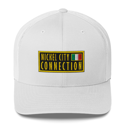 White trucker hat featuring an embroidered patch design featuring the text "NICKEL CITY CONNECTION" in bold, yellow capital letters on a black background. The text is enclosed in a yellow rectangular border. To the right of the text, there is a small embroidered Italian flag with green, white, and red vertical stripes, also bordered in yellow.