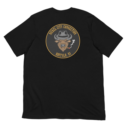 Black t-shirt with a Logo featuring a stylized bison head wearing a fedora, smoking a cigar with visible smoke. The circular design includes bold gold text reading 'Nickel City Connection' at the top and 'Buffalo, NY' at the bottom, outlined in gold against a black background.